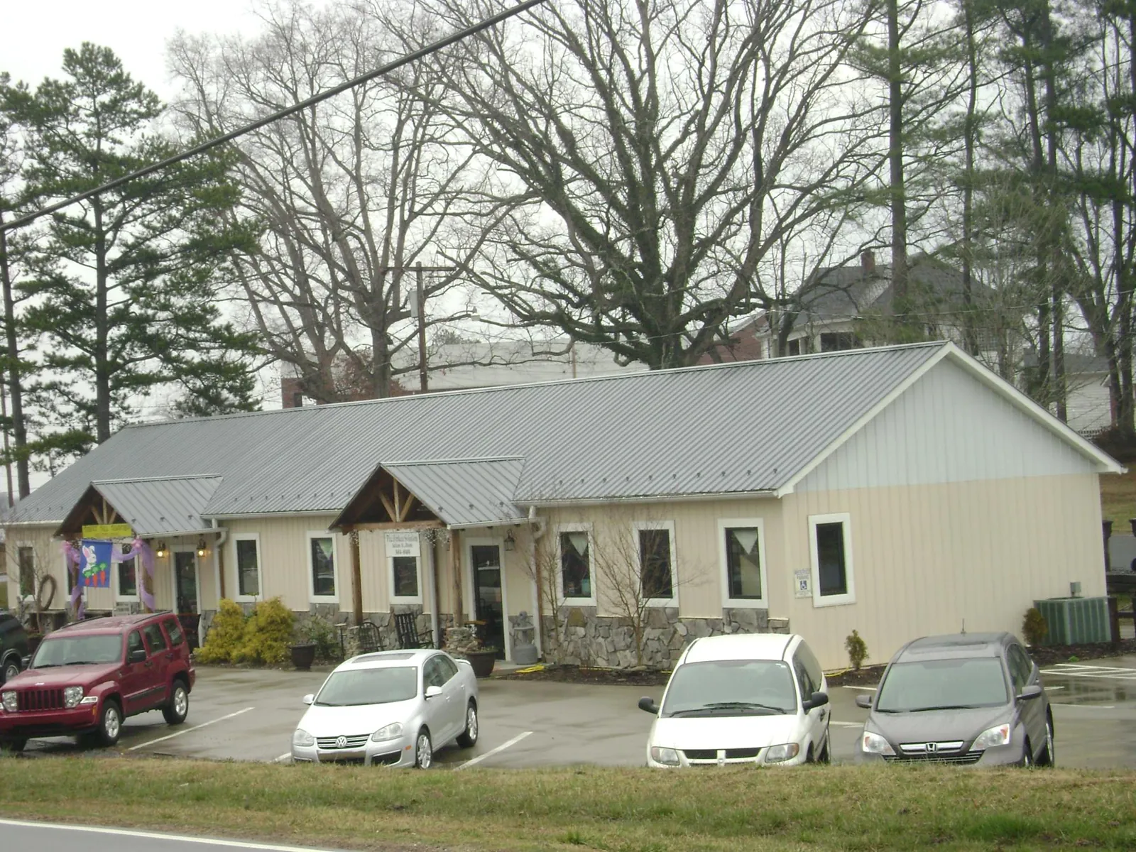 Gray metal roof with timber entry brackets on a small commercial building in Angola